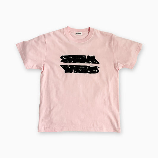 ピンクのTシャツ、胸に黒のロゴプリント付き