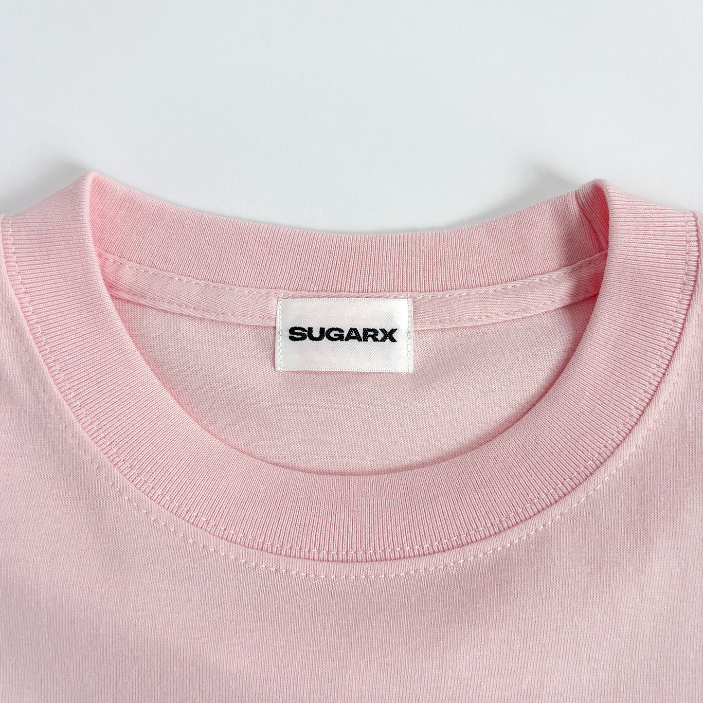 ピンクのクルーネックTシャツ、SUGARXタグ付き