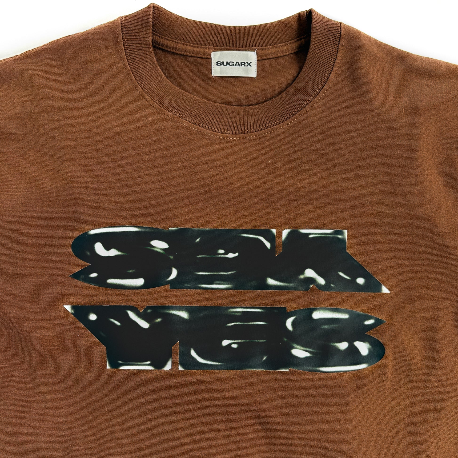 ブラウンのクルーネックTシャツ、フロントに黒の大判プリント