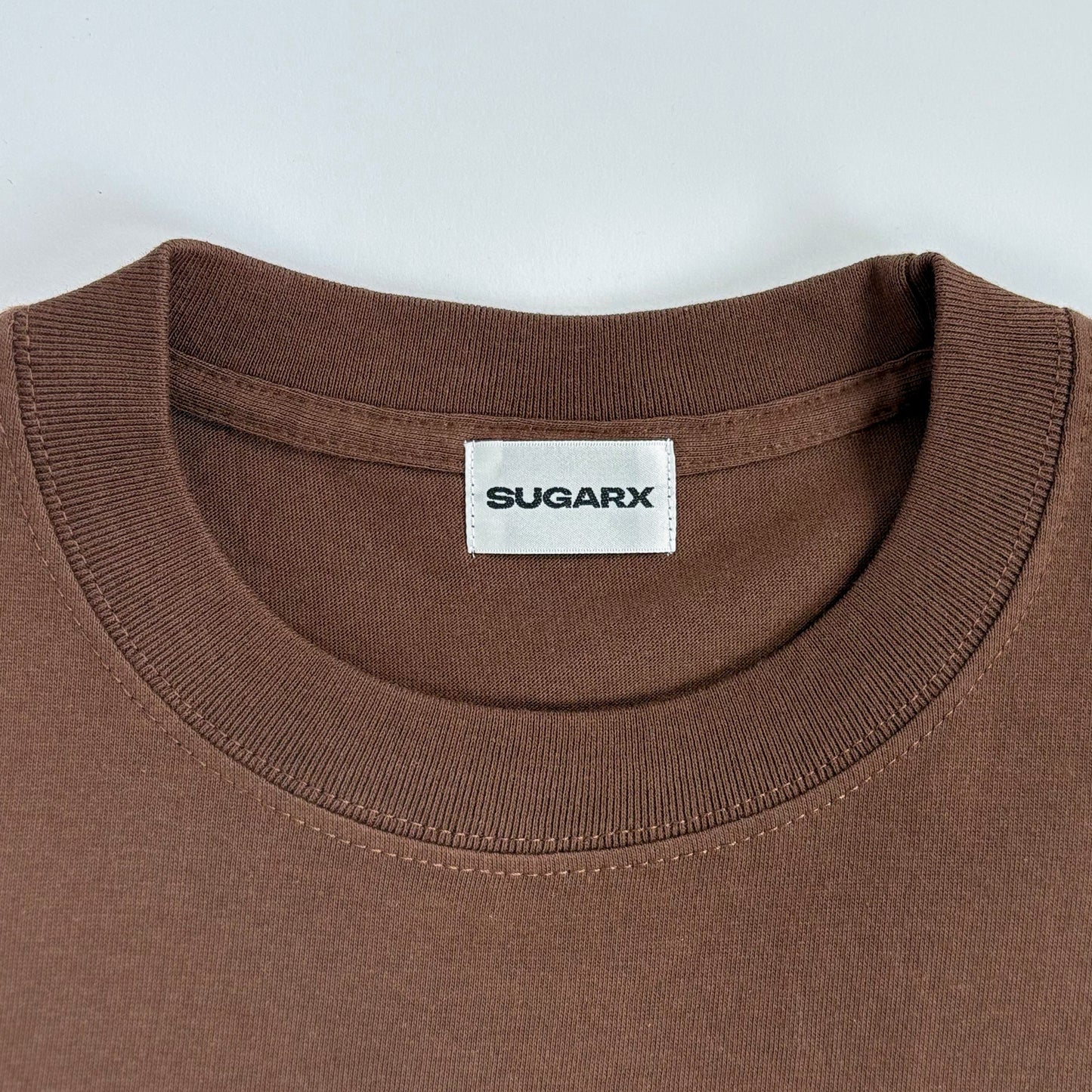 ブラウンのクルーネックTシャツ、SUGARXタグ付き