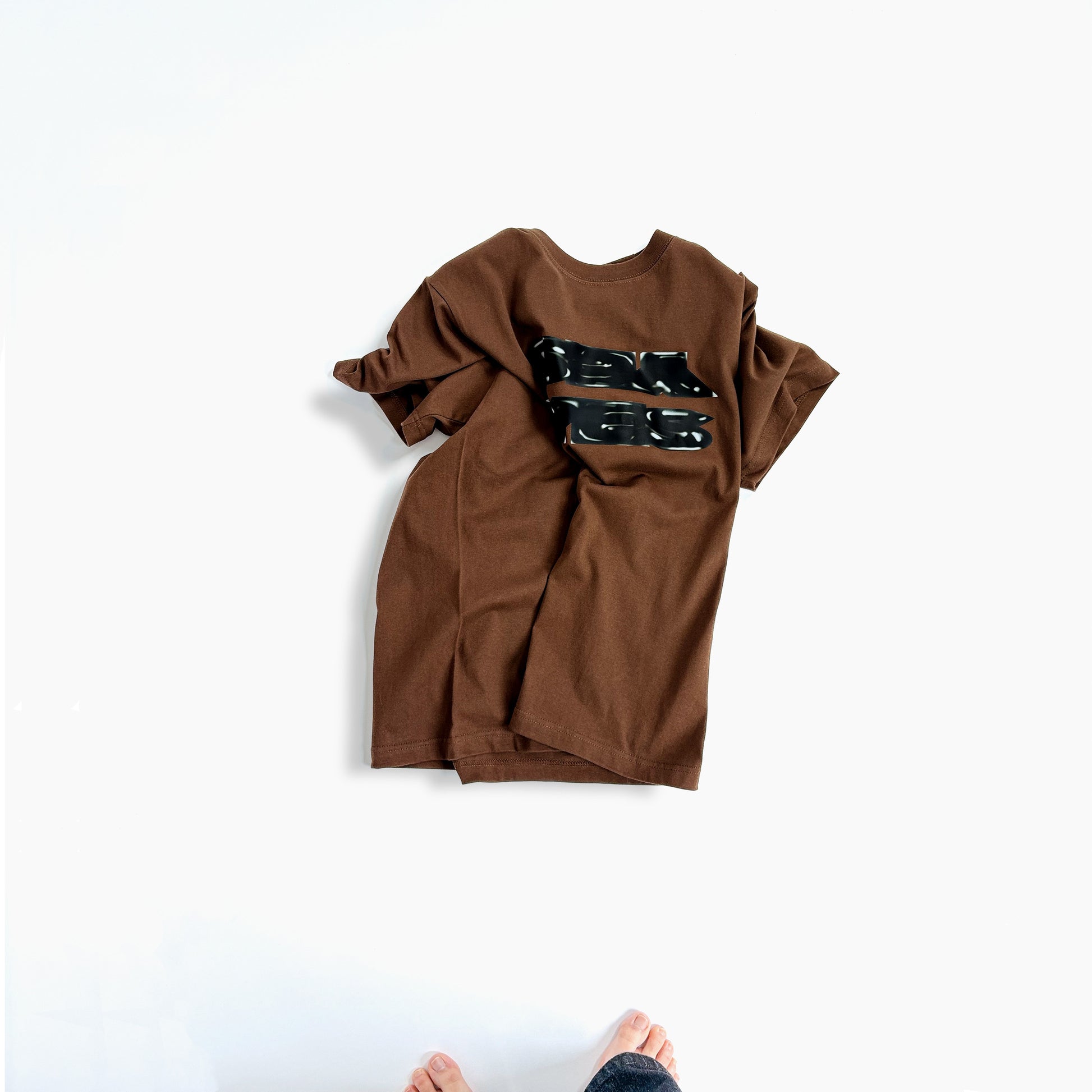 ブラウンのTシャツ、黒グラフィックプリント（前面）
