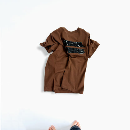 ブラウンのTシャツ、黒グラフィックプリント（前面）
