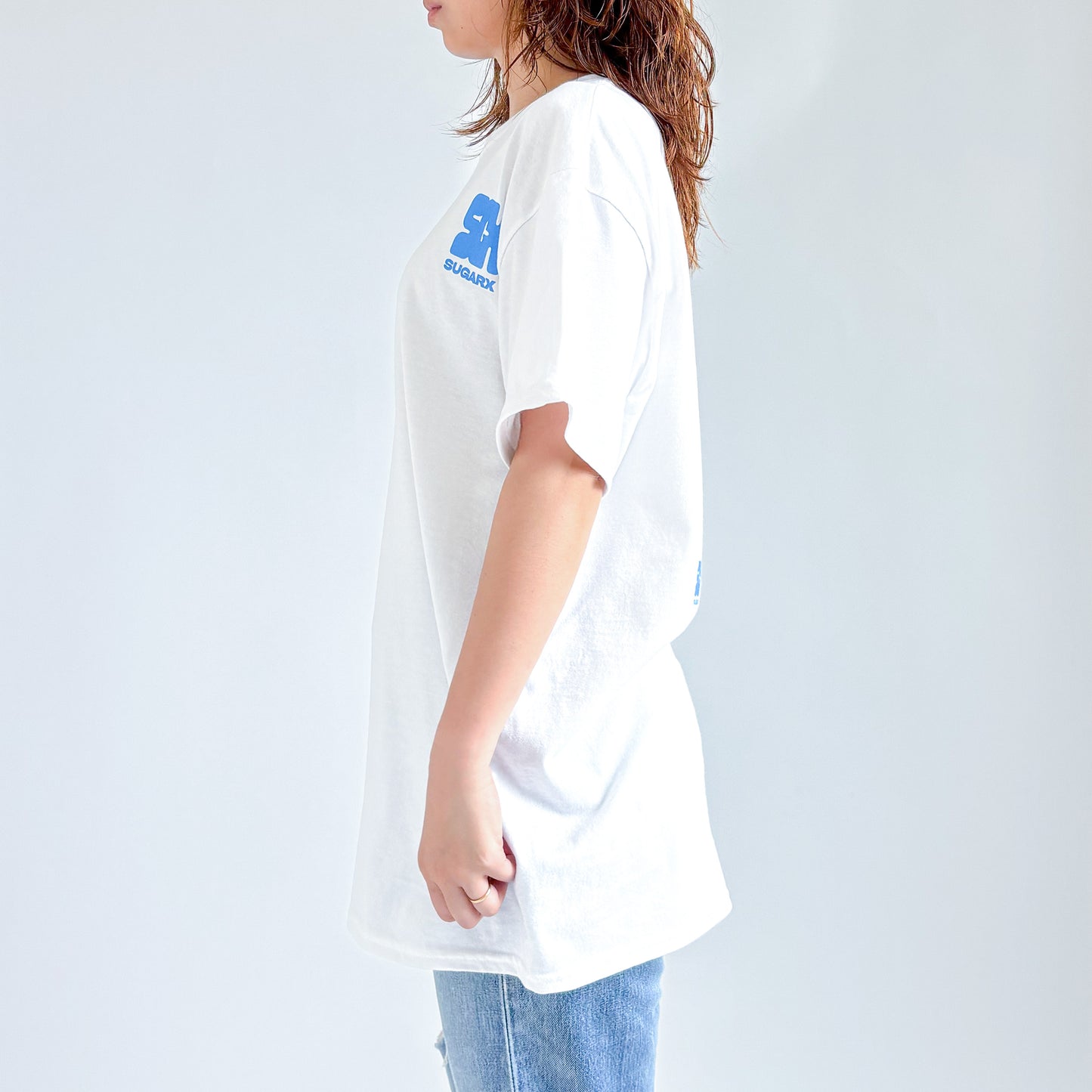 白のTシャツ、背面側に青いSUGARXロゴのプリント