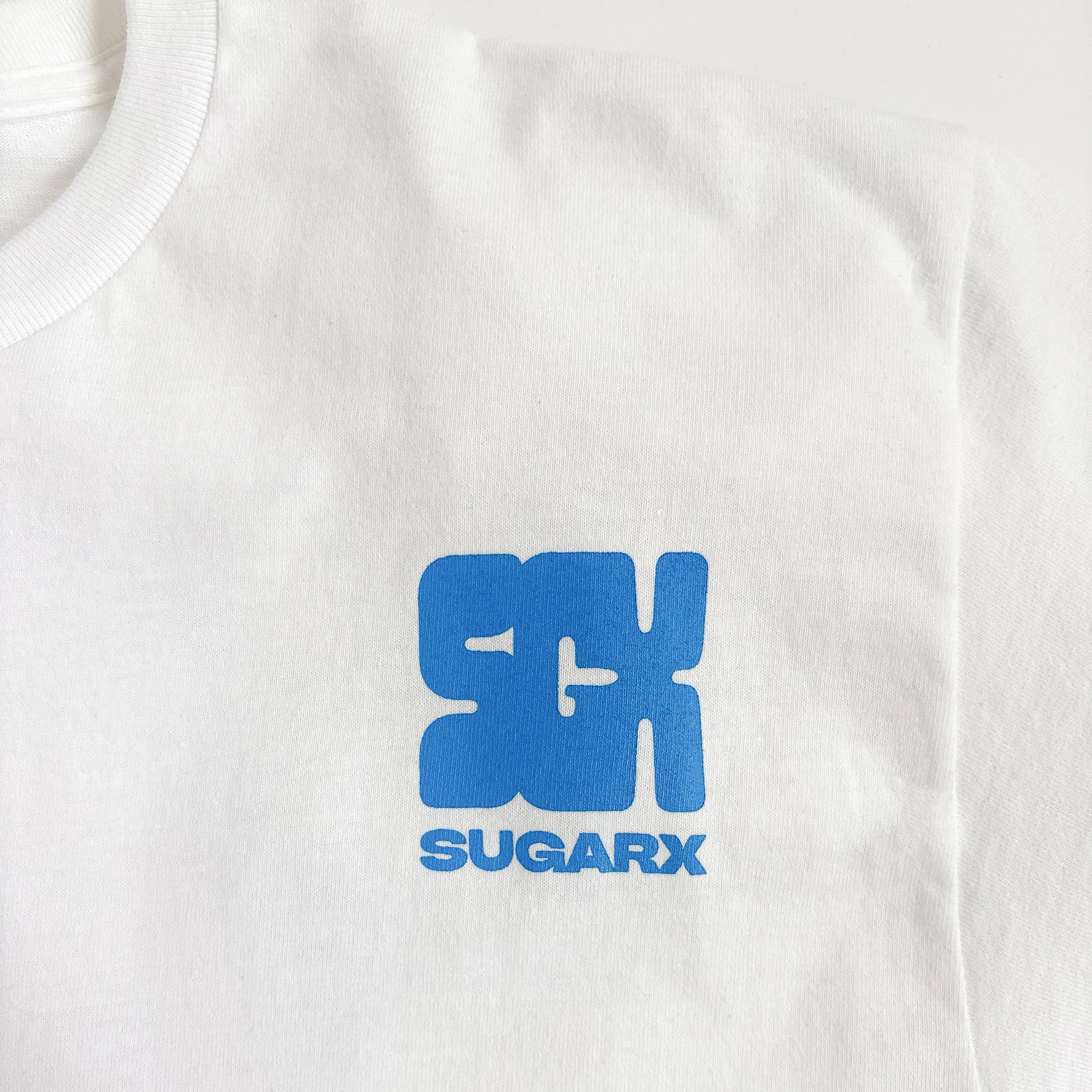 白のTシャツ、青いSUGARXロゴのアッププリント