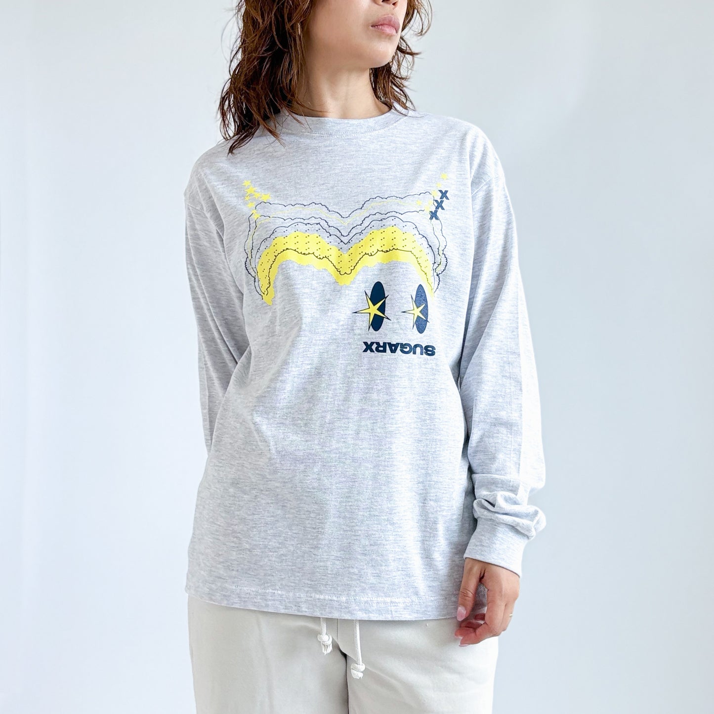 杢グレーの長袖Tシャツ、フロントに黄色と青のプリント