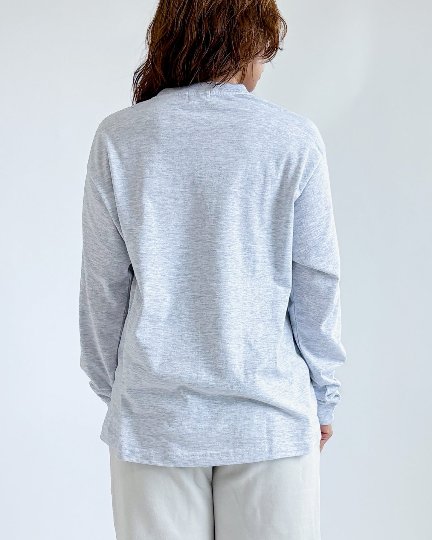 グレーの長袖Tシャツ、背面は無地でクルーネック、裾までカバー