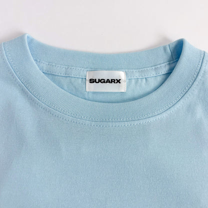 サックスブルー長袖Tシャツのクルーネック、SUGARXタグ付き